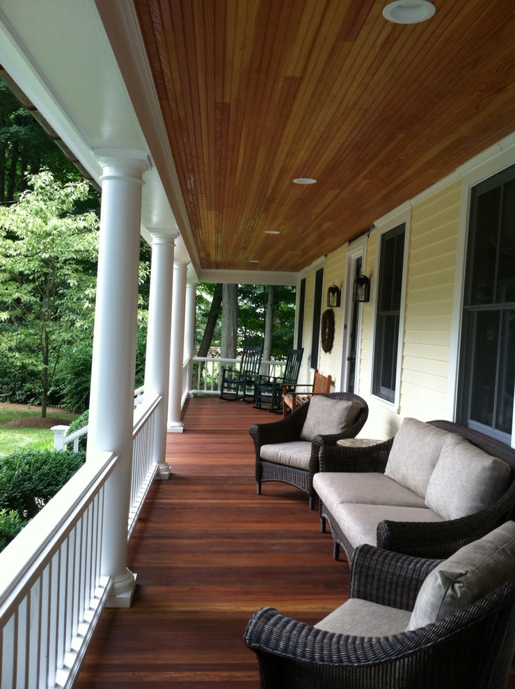 Idée de décoration pour un grand porche d'entrée de maison avant tradition avec une terrasse en bois et une extension de toiture.
