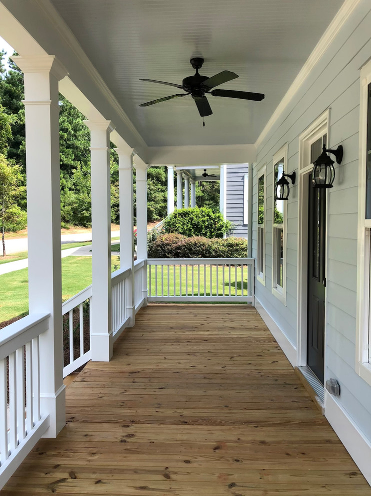 This is an example of a mid-sized cottage front porch design in Atlanta with decking and a roof extension.