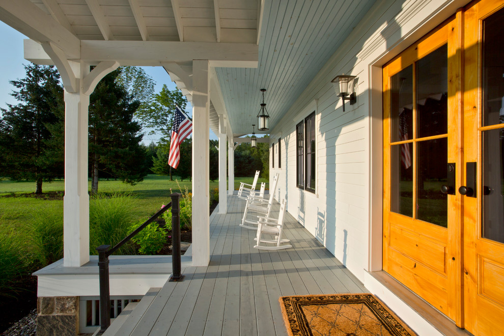 Aménagement d'un grand porche d'entrée de maison avant campagne avec une terrasse en bois et une extension de toiture.