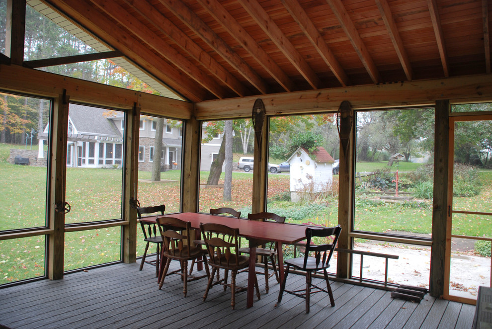 Ejemplo de porche cerrado de estilo de casa de campo grande en patio lateral y anexo de casas con entablado