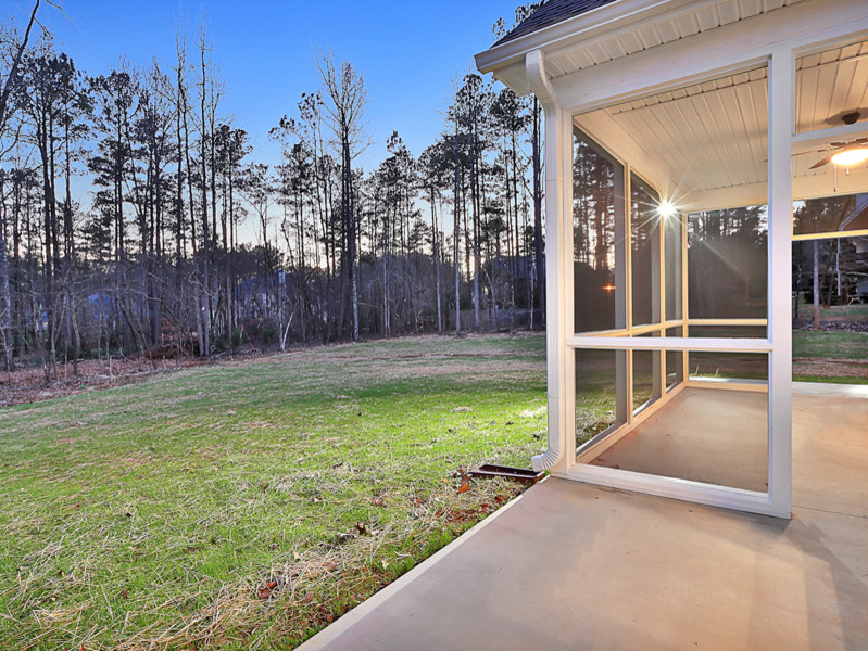This is an example of a medium sized classic back screened veranda in Atlanta with concrete slabs and a roof extension.