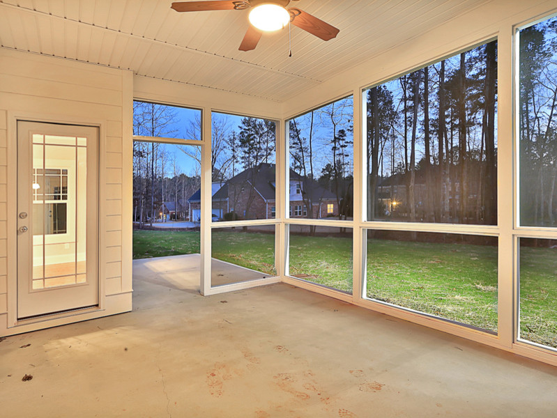 Cette photo montre un porche d'entrée de maison arrière chic de taille moyenne avec une moustiquaire, une dalle de béton et une extension de toiture.