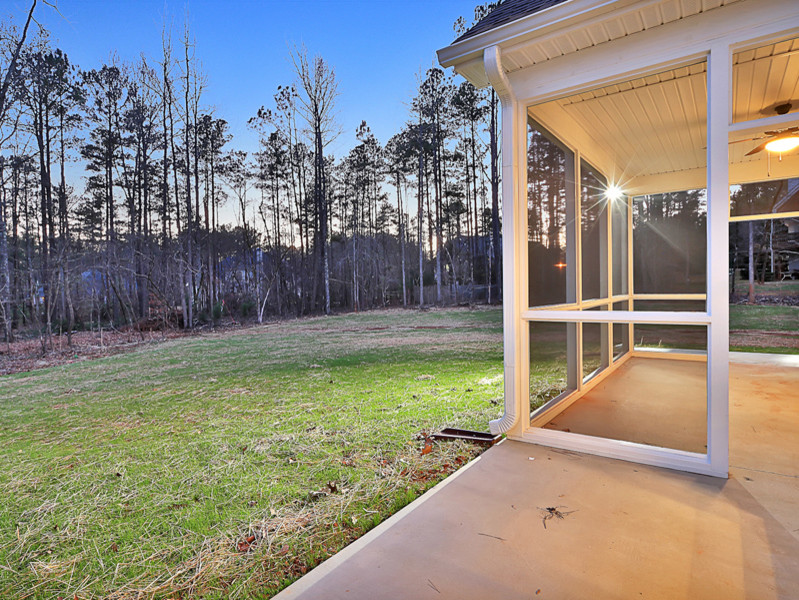 Exemple d'un porche d'entrée de maison arrière chic de taille moyenne avec une moustiquaire, une dalle de béton et une extension de toiture.