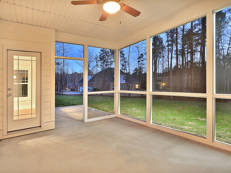 Immagine di un portico classico di medie dimensioni e dietro casa con un portico chiuso, lastre di cemento e un tetto a sbalzo
