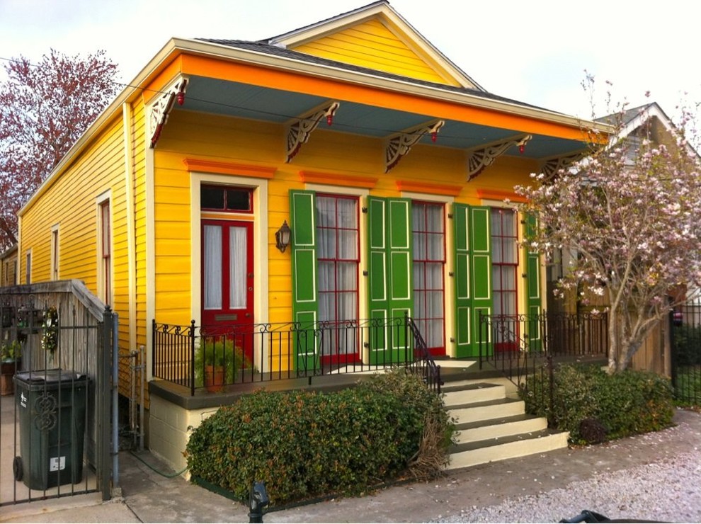 Mid-sized ornate front porch idea in New Orleans with a roof extension