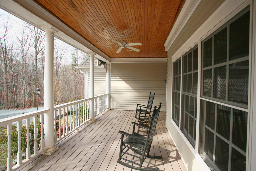 This is an example of a mid-sized traditional front porch design in Raleigh with decking and a roof extension.