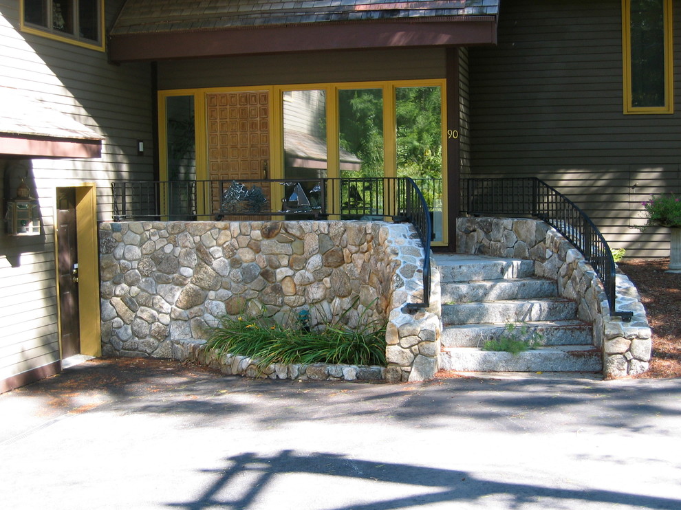 Immagine di un grande portico classico davanti casa con lastre di cemento