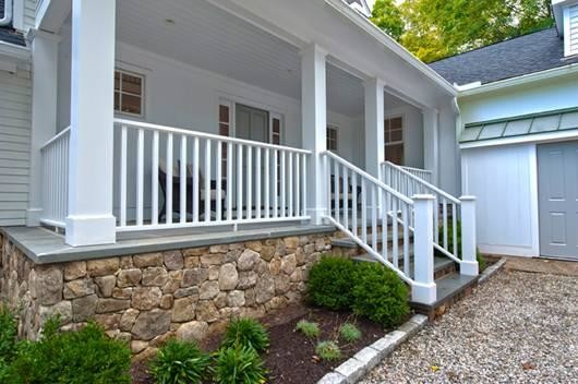 This is an example of a mid-sized eclectic stone porch design in New York with a roof extension.