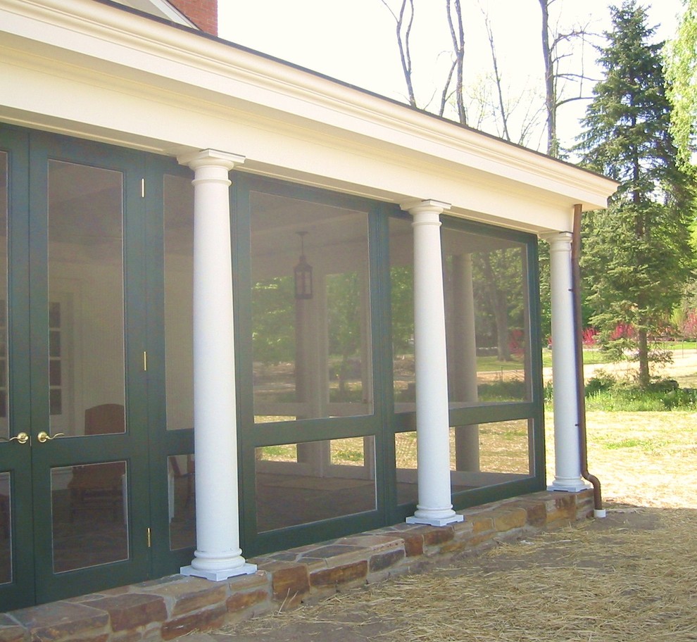 Large farmhouse stone screened-in side porch photo in New York with a roof extension