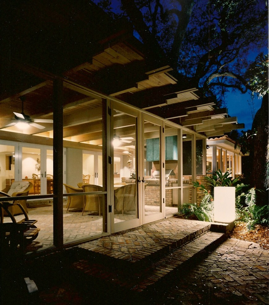На фото: веранда среднего размера на заднем дворе в современном стиле с крыльцом с защитной сеткой, мощением клинкерной брусчаткой и навесом с