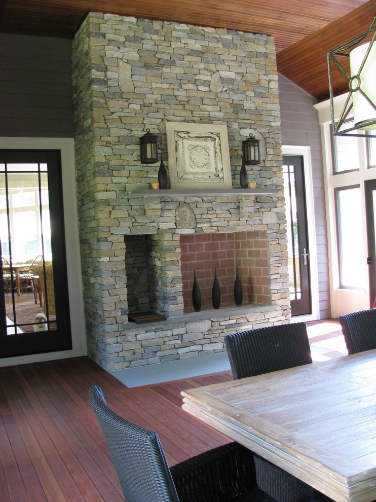 Idée de décoration pour un porche d'entrée de maison latéral tradition avec une cheminée et une terrasse en bois.