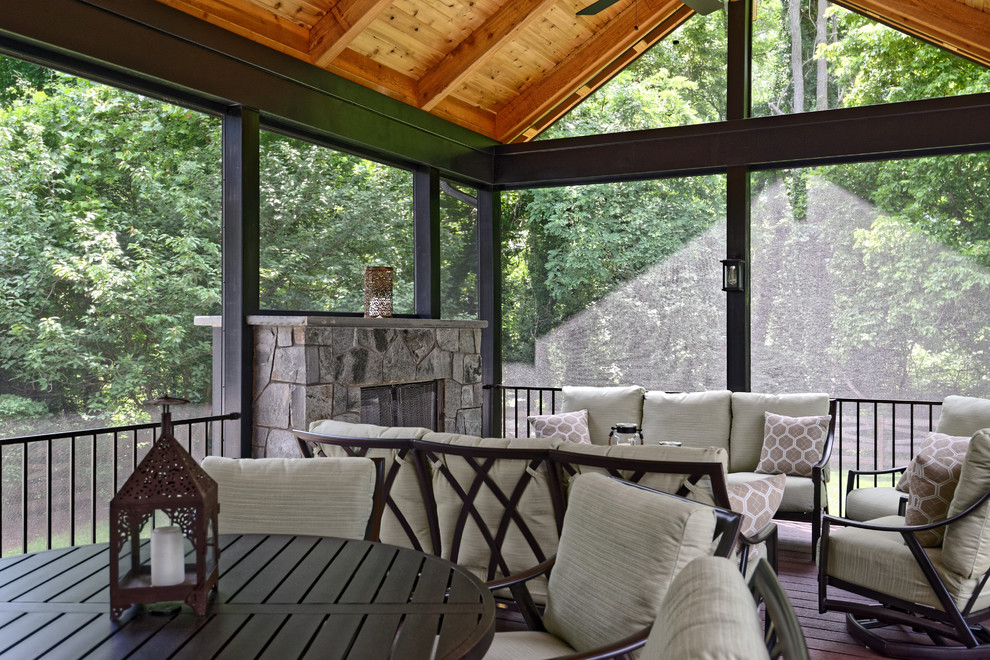 Idée de décoration pour un porche d'entrée de maison arrière chalet de taille moyenne avec un foyer extérieur et une terrasse en bois.