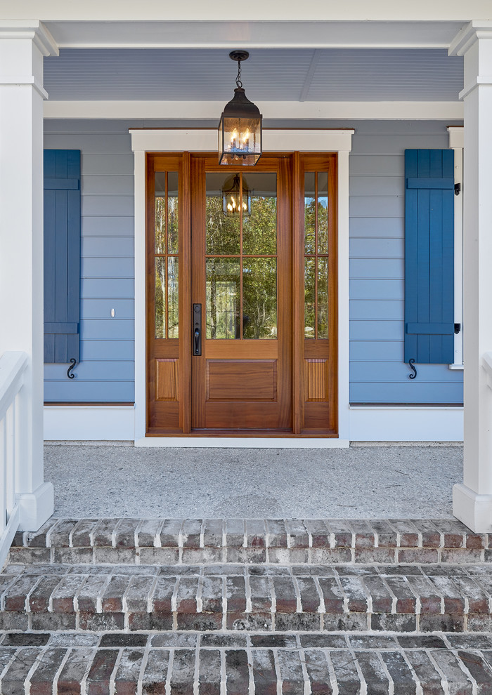 This is an example of a mid-sized traditional front porch design in Charleston with a roof extension.
