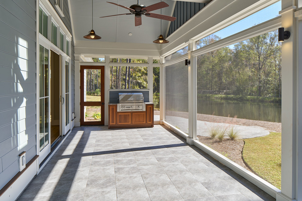 Inspiration pour un grand porche d'entrée de maison arrière traditionnel avec une extension de toiture, une cuisine d'été et des pavés en pierre naturelle.