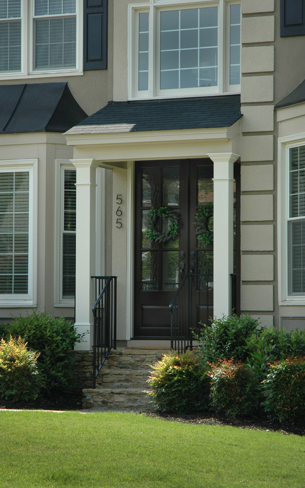 Immagine di un portico classico di medie dimensioni e davanti casa con pavimentazioni in mattoni e un tetto a sbalzo