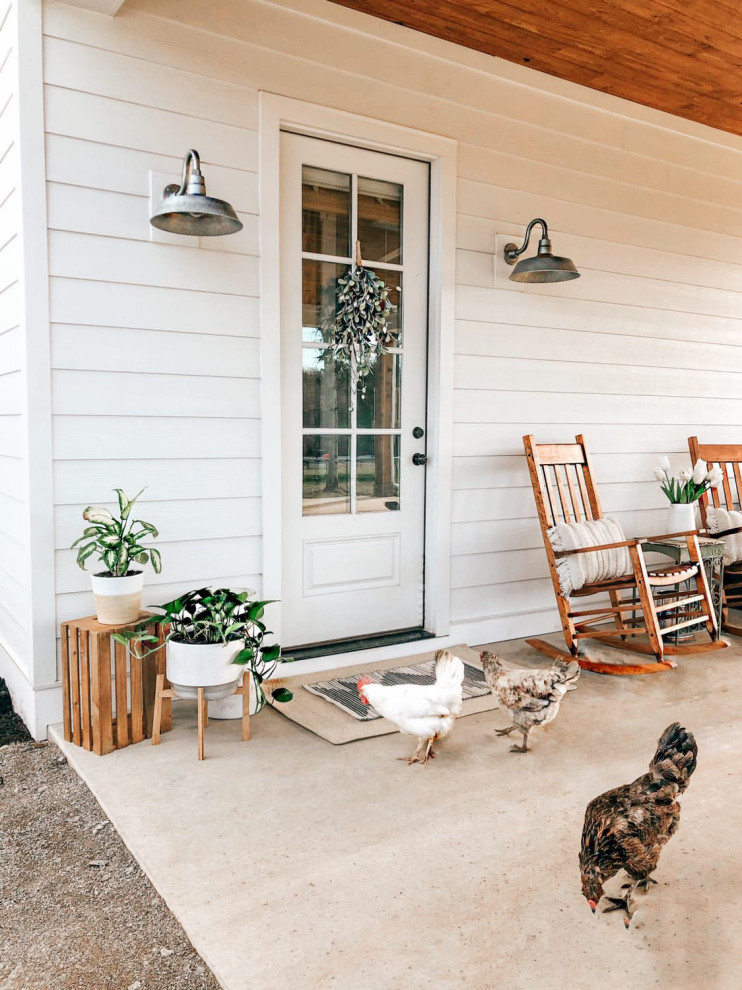 Exemple d'un grand porche d'entrée de maison arrière nature avec une dalle de béton et une pergola.