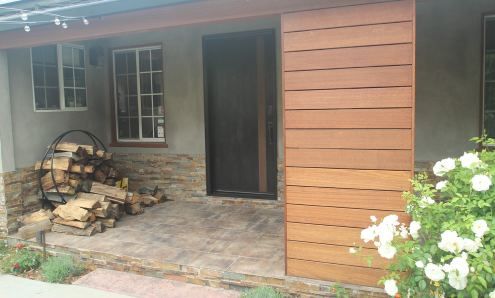 Inspiration pour un porche d'entrée de maison avant minimaliste de taille moyenne avec des pavés en pierre naturelle et une extension de toiture.