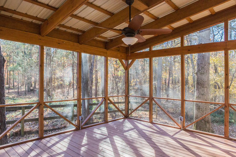 Idée de décoration pour un grand porche d'entrée de maison arrière champêtre avec une moustiquaire, une terrasse en bois et une extension de toiture.