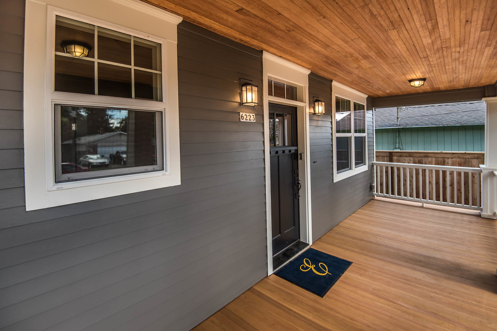 Inspiration pour un porche d'entrée de maison avant craftsman avec une terrasse en bois et une extension de toiture.