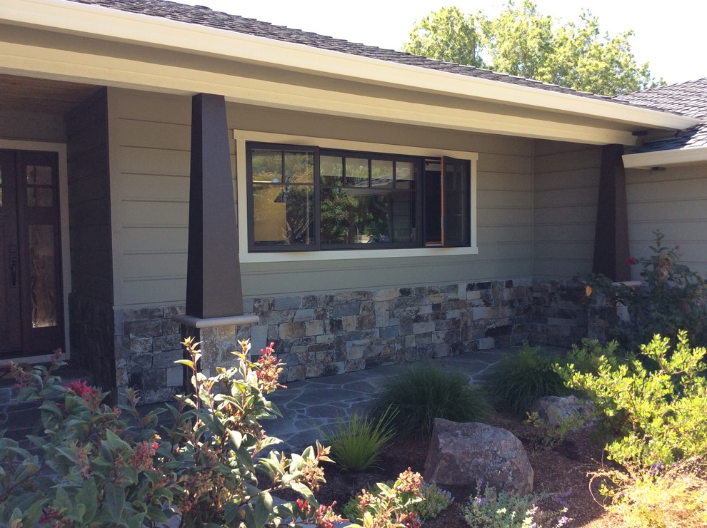Imagen de terraza de estilo americano de tamaño medio en patio delantero y anexo de casas con adoquines de piedra natural