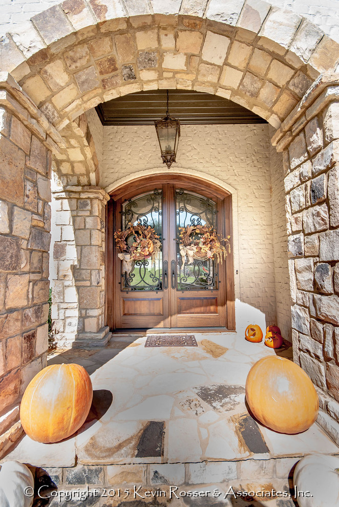 Cette photo montre un porche d'entrée de maison avant chic de taille moyenne avec des pavés en pierre naturelle et une extension de toiture.