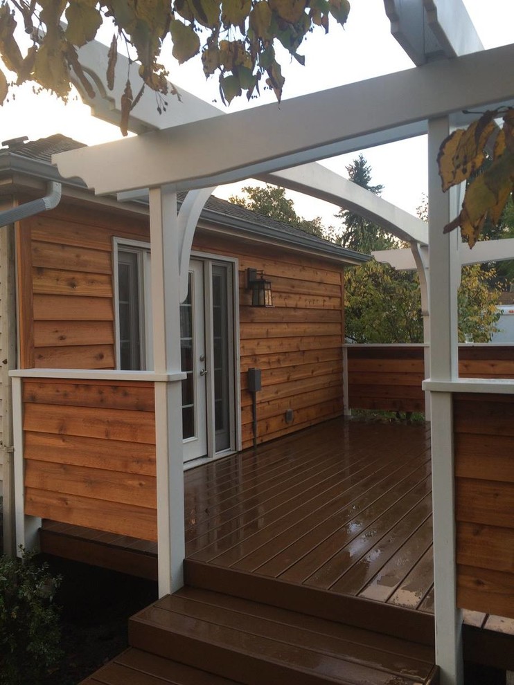 Mid-sized elegant back porch photo in Portland with decking and a pergola