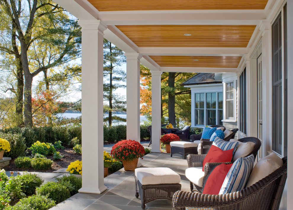 Large elegant stone front porch photo in Boston with a roof extension