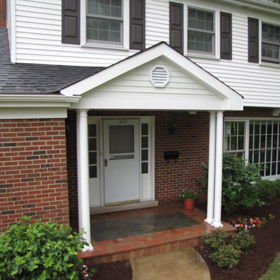 This is an example of a small classic front veranda in Chicago with brick paving and a roof extension.