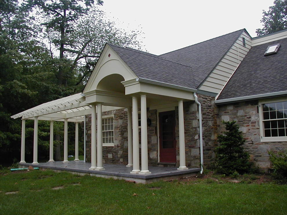 Foto på en stor amerikansk veranda framför huset, med stämplad betong och takförlängning