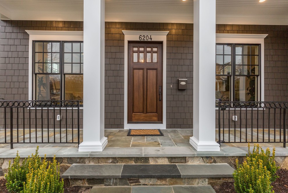 Esempio di un grande portico american style davanti casa con pavimentazioni in pietra naturale e un tetto a sbalzo