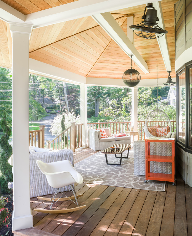 Cette image montre un porche d'entrée de maison avant traditionnel avec une terrasse en bois et une extension de toiture.