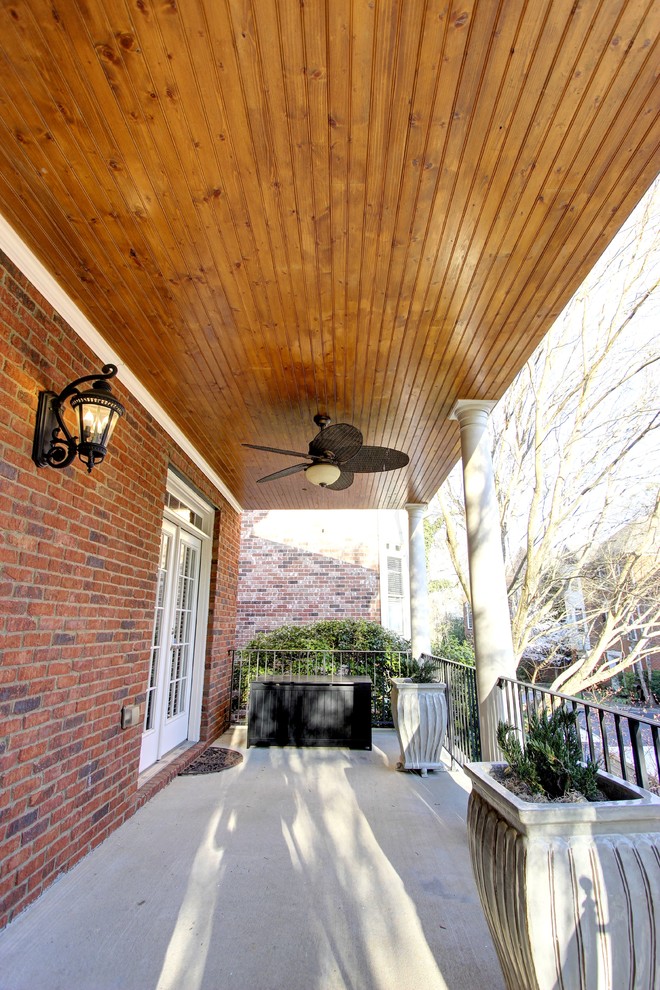 Inspiration for a small transitional concrete front porch remodel in Atlanta with a roof extension