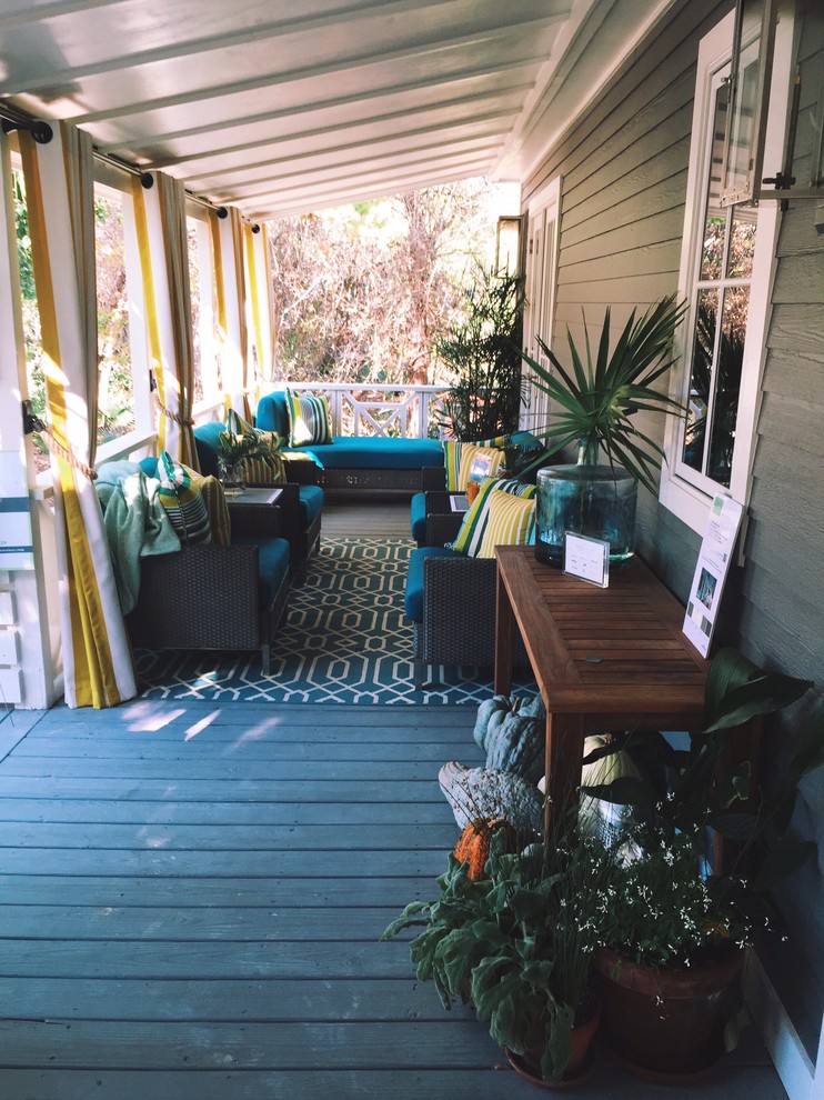 This is an example of a large eclectic front veranda in Miami with decking and a roof extension.