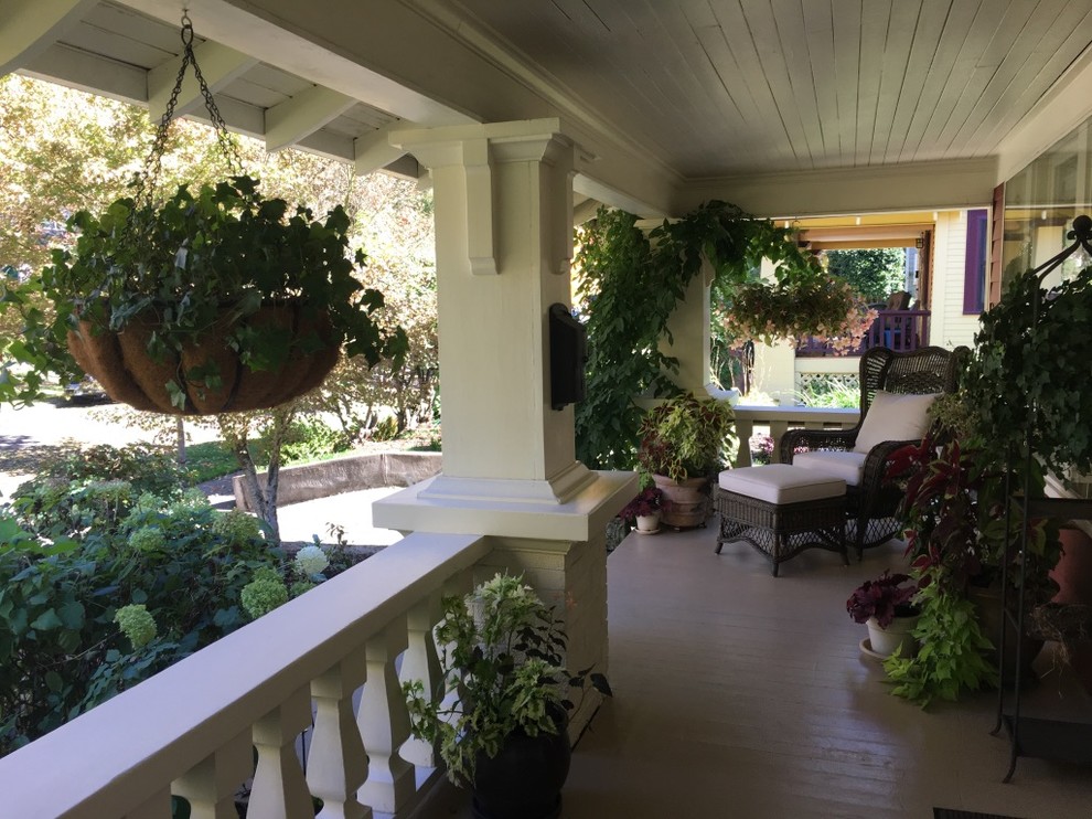 Esempio di un portico american style di medie dimensioni e davanti casa con un giardino in vaso, pedane e un tetto a sbalzo