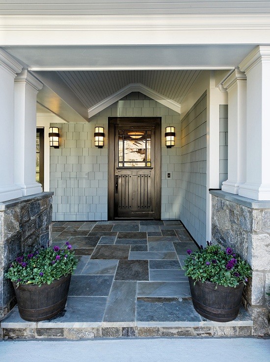 Inspiration for a large timeless stone front porch remodel in DC Metro with a roof extension