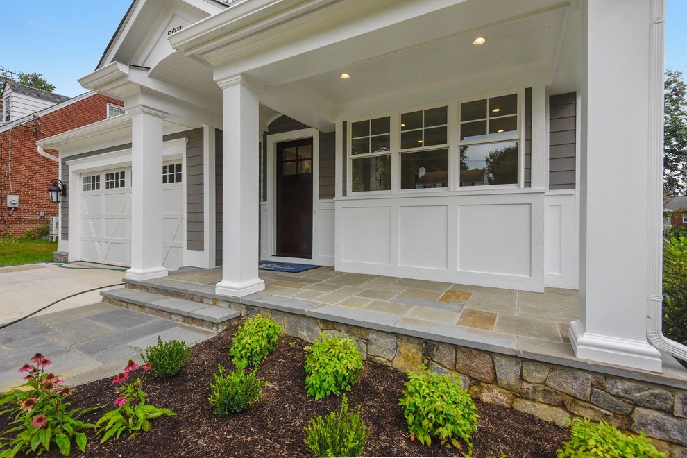 Exemple d'un porche d'entrée de maison avant de taille moyenne avec des pavés en pierre naturelle et une extension de toiture.