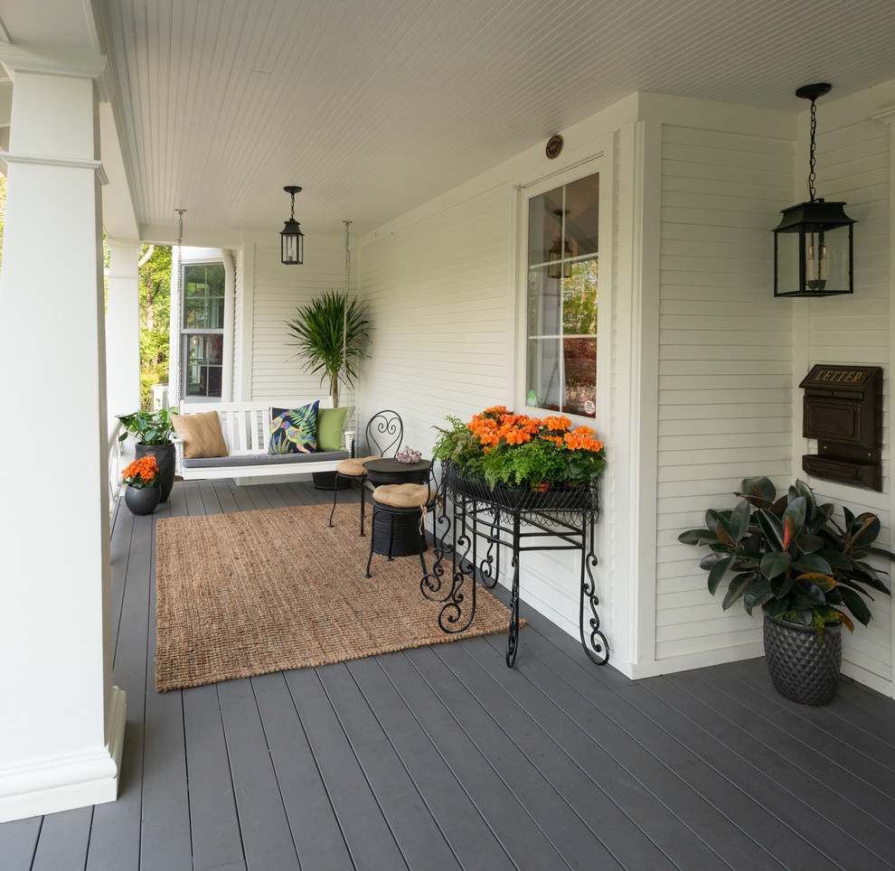 Ejemplo de terraza de estilo de casa de campo de tamaño medio en anexo de casas y patio delantero con iluminación