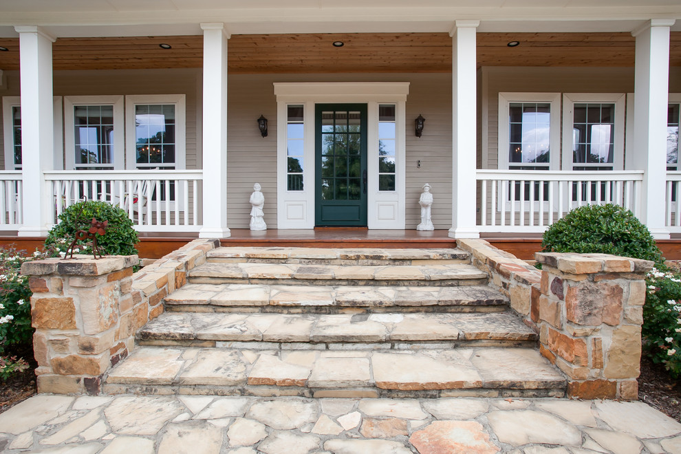 Cette photo montre un grand porche d'entrée de maison avant nature avec une terrasse en bois et une extension de toiture.