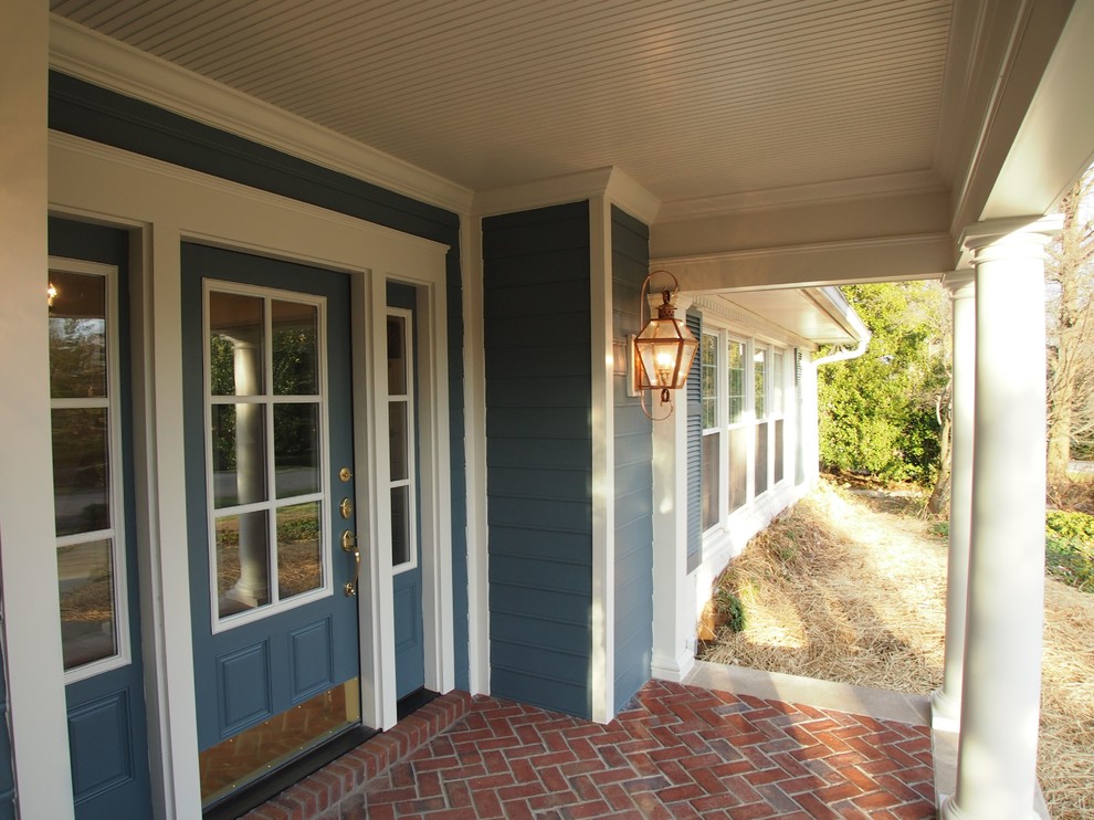 Inspiration pour un porche d'entrée de maison avant traditionnel de taille moyenne avec des pavés en brique et une extension de toiture.
