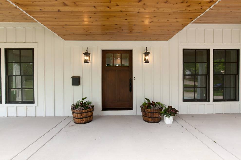 Inspiration for a large farmhouse front veranda in Chicago with concrete slabs, a roof extension and with columns.
