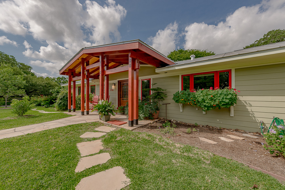 Large zen stone front porch photo in Austin with an awning