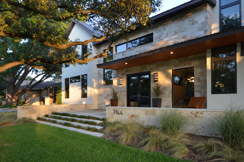 Large modern front veranda in Dallas with concrete slabs and an awning.