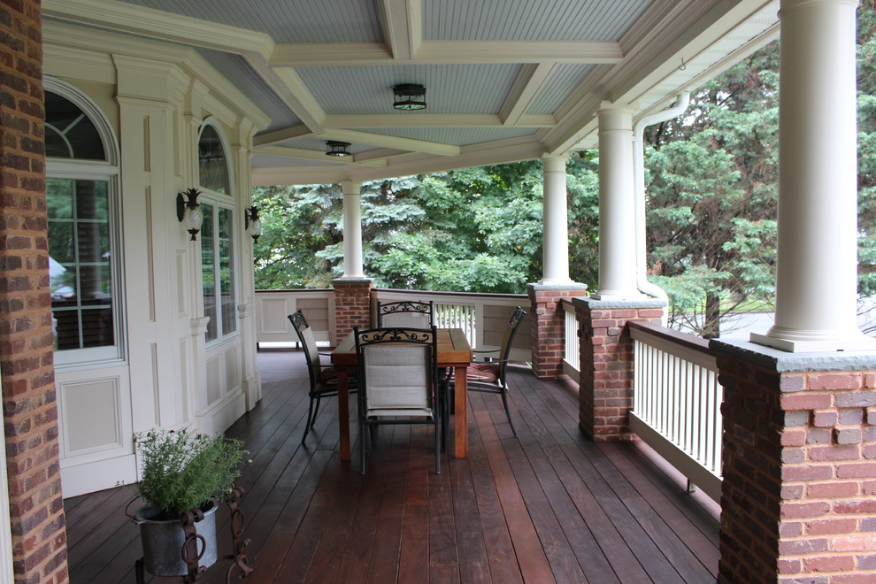 Inredning av en klassisk stor veranda framför huset, med trädäck och takförlängning