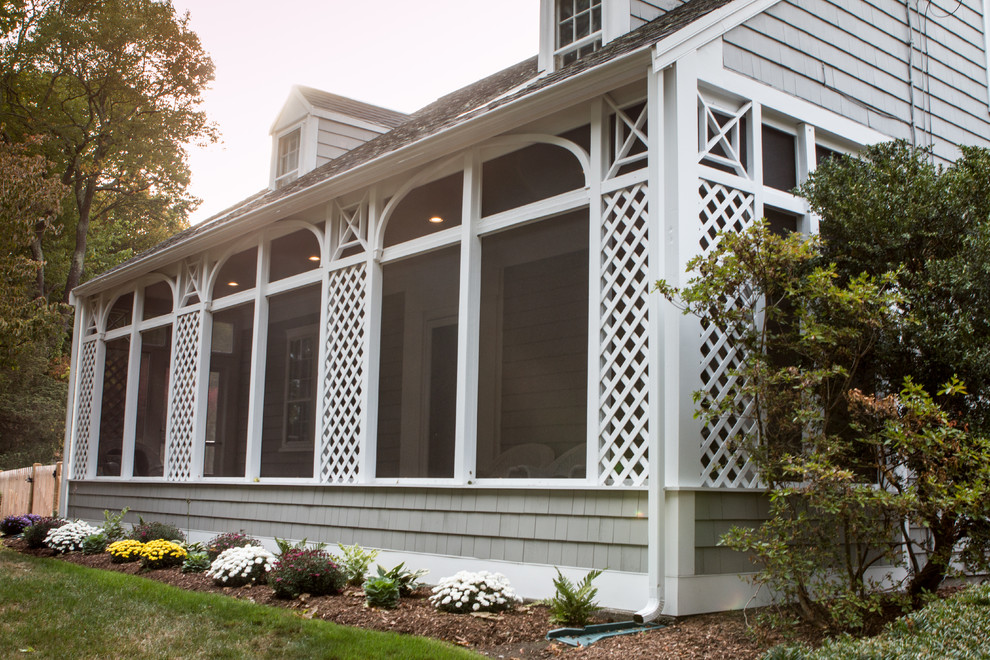 Inspiration pour un grand porche d'entrée de maison avant craftsman avec une moustiquaire, une terrasse en bois et une extension de toiture.