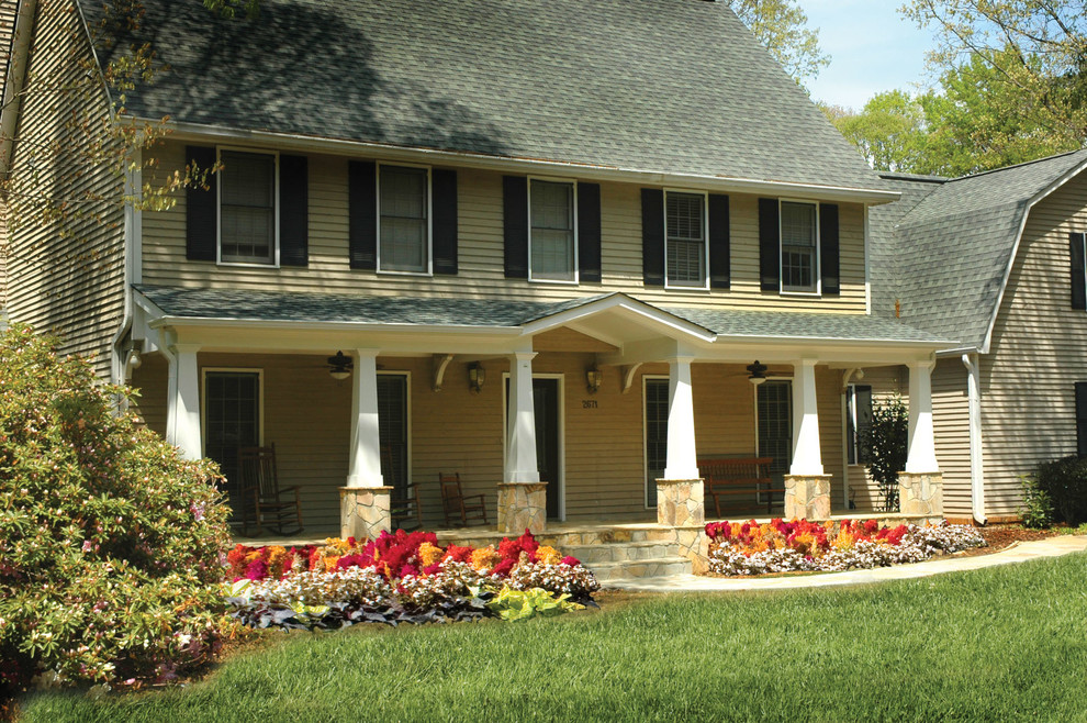 Idée de décoration pour un grand porche d'entrée de maison avant tradition avec des pavés en pierre naturelle et une extension de toiture.