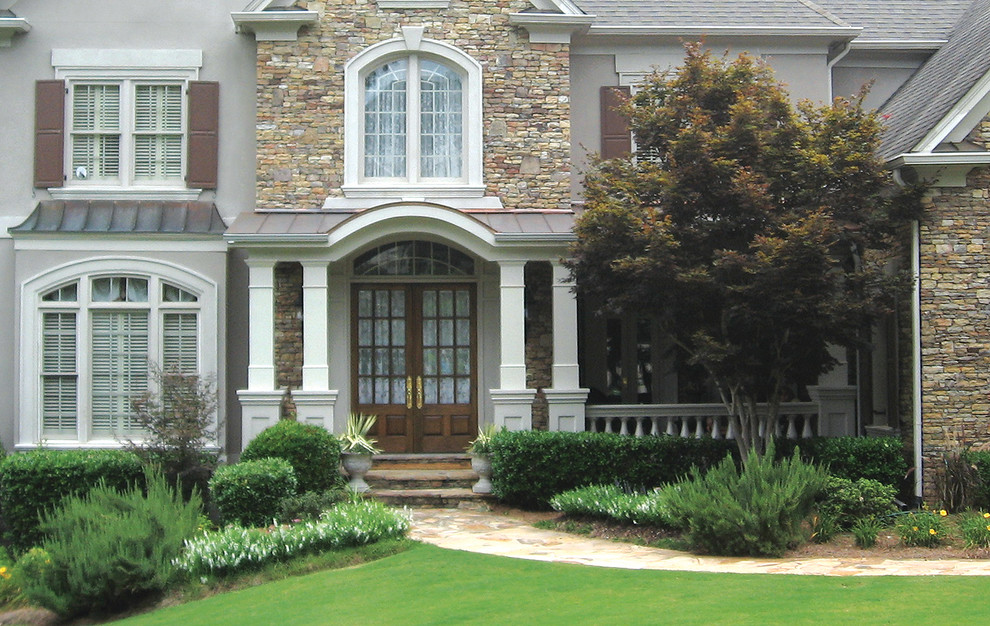 Immagine di un portico tradizionale di medie dimensioni e davanti casa con pavimentazioni in pietra naturale e un tetto a sbalzo