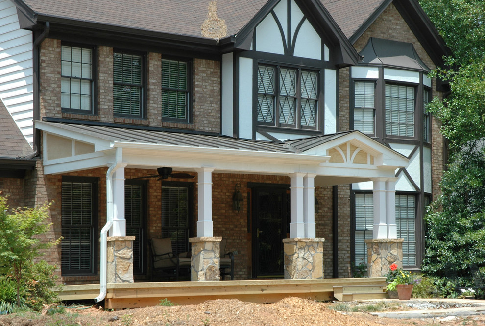 This is an example of a medium sized classic front veranda in Atlanta with natural stone paving and a roof extension.
