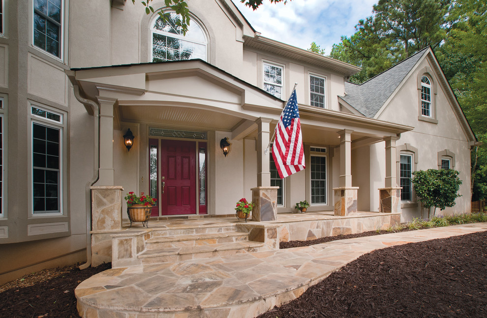 Inspiration pour un grand porche d'entrée de maison avant traditionnel avec une extension de toiture et des pavés en pierre naturelle.