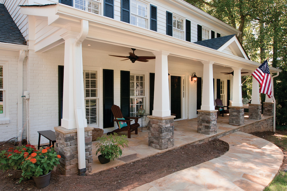 Esempio di un grande portico american style davanti casa con pavimentazioni in pietra naturale e un tetto a sbalzo