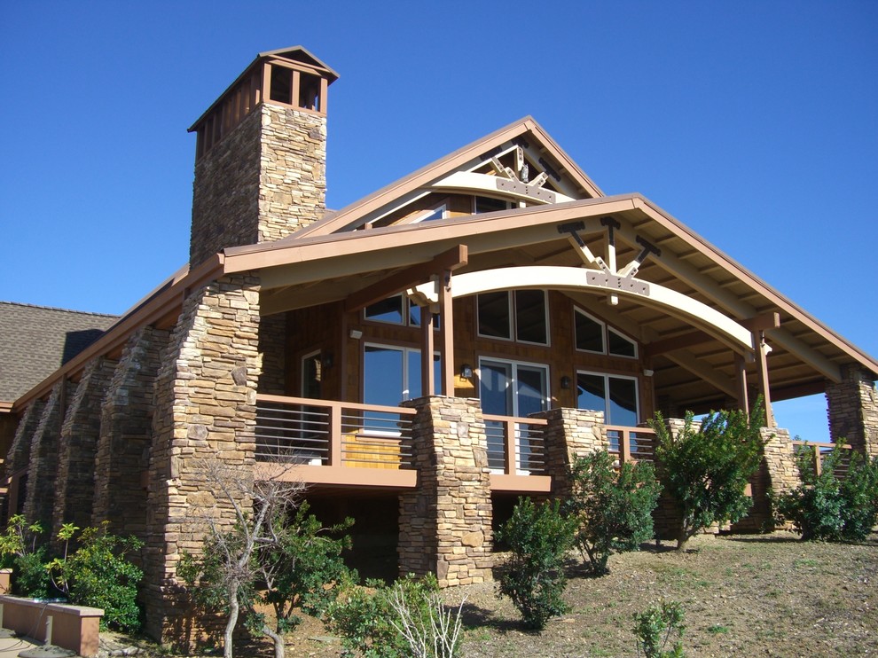 Idee per un grande portico stile americano dietro casa con un focolare, pavimentazioni in pietra naturale e un tetto a sbalzo